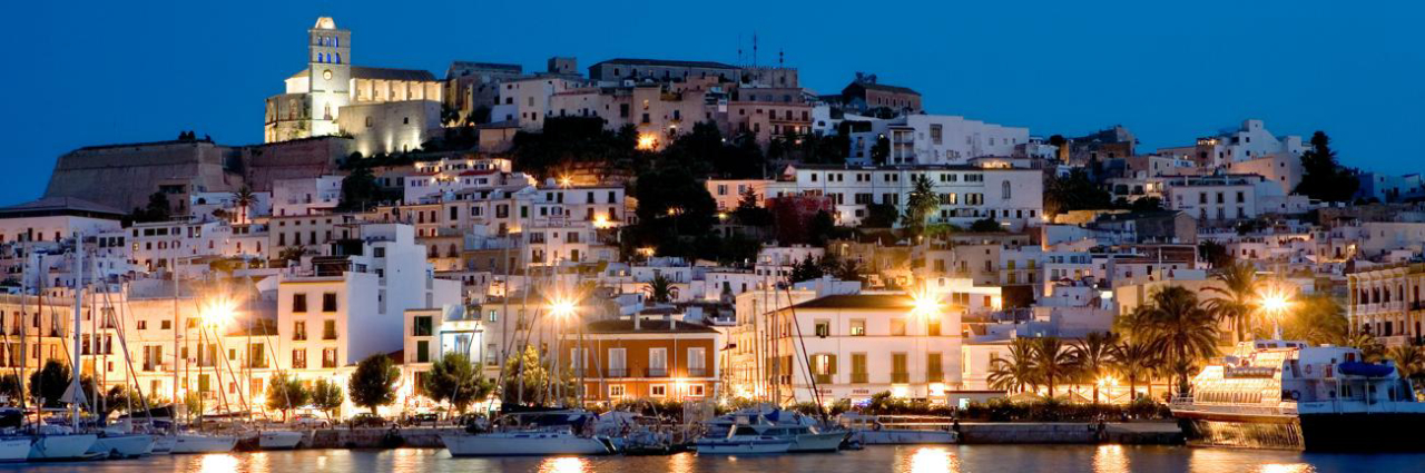 O belo cenário a noite da parte antiga de Ibiza e do concorrido porto, repleto de lojas, bares e restaurantes charmosos.