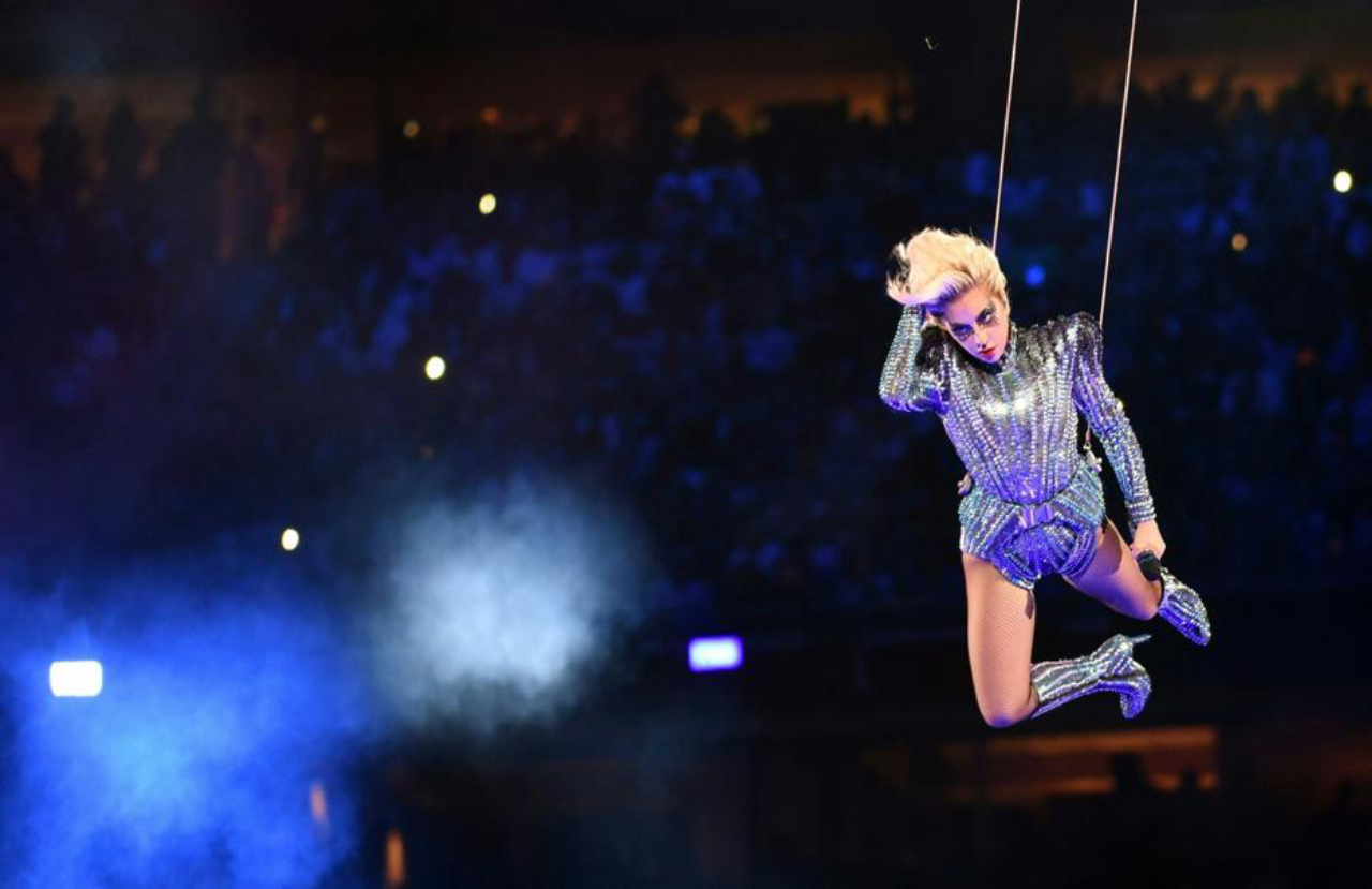Gaga vestiu um body de mangas longas (e ombreiras) todo bordado com pedras espelhadas com botas de cano longo do mesmo material. Foto: AFP