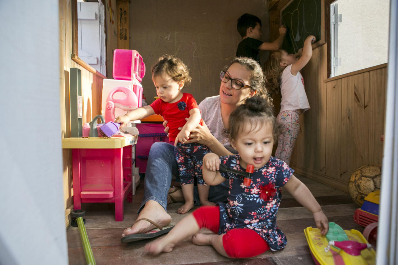 Enquanto Felipe e Manuela se divertem com um quadro negro, Isabela e Gabriela ganham colo e atenção da mãe, Luiza. Foto Marcelo Andrade/Gazeta do Povo