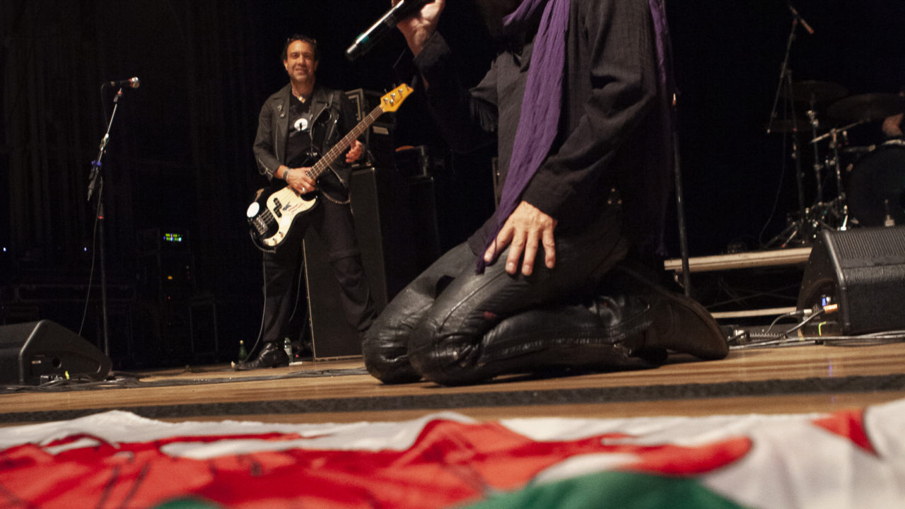 Michael Aston diante da bandeira do País de Gales que recebeu de alguém da plateia na Ópera de Arame, na última quarta-feira, 26. Foto: Marcos Mancinni